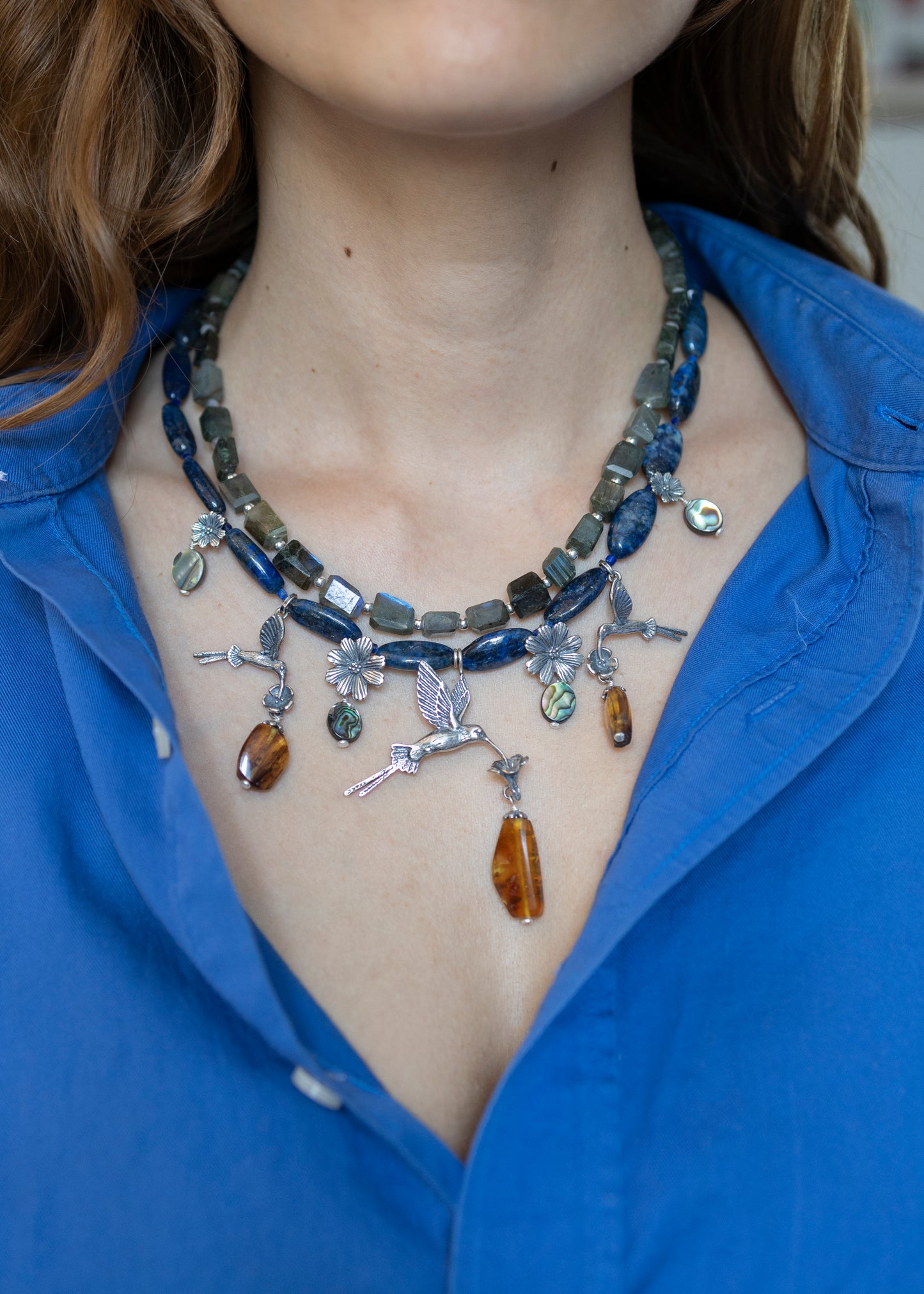 Collar colibríes en el campo de flores